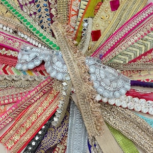 Peut inclure: Une collection vibrante de rubans et de garnitures décoratives de différentes couleurs et textures. L'assortiment comprend des motifs brodés métalliques or et argent, ainsi que des embellissements tels que des paillettes et des miroirs. Idéal pour les projets d'artisanat.