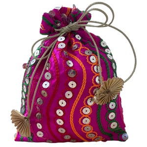 May include: A vibrant fuchsia drawstring pouch adorned with silver sequins and intricate embroidery in orange, green, and red. The bag features a gold-colored drawstring and decorative tassels, perfect for carrying small items.