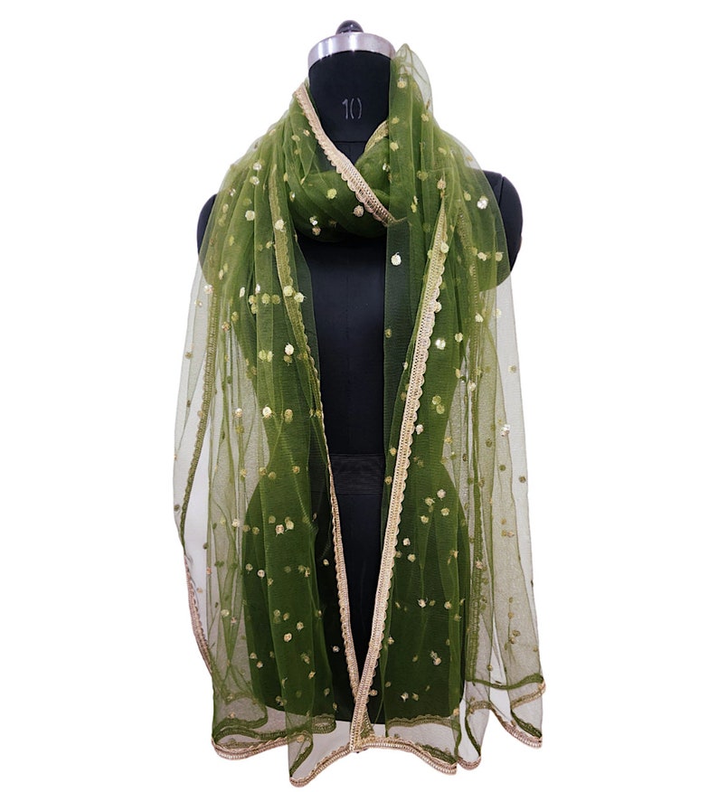 May include: A green net scarf with gold sequins and a gold trim. The scarf is draped over a mannequin.