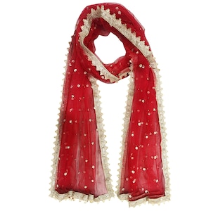 May include: A red sheer scarf with gold trim and sequins. The scarf has a delicate lace border.