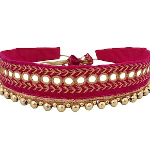 Könnte beinhalten: Eine rosafarbene Samt-Choker-Halskette mit goldener Stickerei und runden Spiegel-Akzenten. Die Halskette ist mit goldenen Perlen verziert.