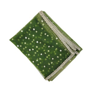 May include: A green sheer scarf with a white polka dot pattern and a gold lace trim.