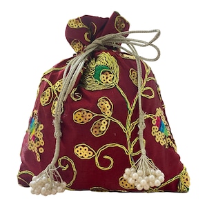 May include: A burgundy drawstring pouch with gold embroidery and sequin accents. The pouch features a peacock feather design and floral patterns. The drawstring is a light gold color and has white beaded tassels.