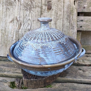 Op de afbeelding: Een set van drie keramische nestkommen in blauwe, groene en witte tinten. De kommen hebben een gespikkelde glazuur en een eenvoudig, modern ontwerp. De grootste kom heeft een diameter van ongeveer 15 cm.