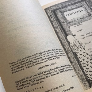 May include: A book cover with the title "CONTENTS" in a black frame. The book is about a child and a cloak. The copyright information is on the back cover.