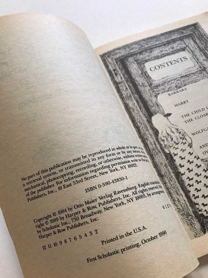 May include: A book cover with the title "CONTENTS" in a black frame. The book is about a child and a cloak. The copyright information is on the back cover.