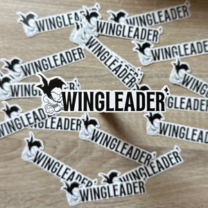 May include: A collection of black and white stickers with the word "WINGLEADER" repeated multiple times. The stickers feature a cartoon bird with a cloud design.