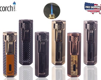 May include: A collection of Scorch torch lighters in various colors and designs. The lighters have a rectangular shape with a push-button ignition and a flame nozzle. Some lighters have a textured finish, while others have a smooth, metallic appearance.