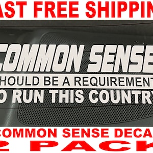 May include: Two white vinyl decals with the text "Common Sense Should Be A Requirement To Run This Country" in black lettering. The decals are on a black background. The text "Common Sense Decal 2 Pack" is in red lettering at the bottom of the image.