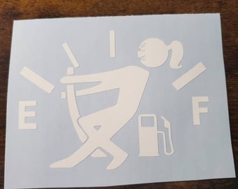 May include: White vinyl decal of a stick figure woman pushing down on a gas gauge that is on 'E'. The figure is holding a gas pump. The gauge is labeled 'E' and 'F'.
