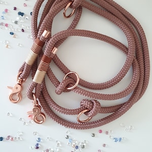 Op de afbeelding: Een set van twee roosgoudkleurige hondenriemen met bijpassende hardware. De riemen zijn gemaakt van zacht, gevlochten touwmateriaal en zijn ontworpen voor dagelijks gebruik.