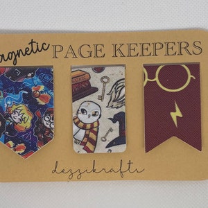 May include: Three magnetic page keepers with a Harry Potter theme. The first page keeper features a blue background with a pattern of Harry Potter characters, the second page keeper features a white background with a pattern of owls, keys, and books, and the third page keeper features a maroon background with a pattern of glasses and a lightning bolt.
