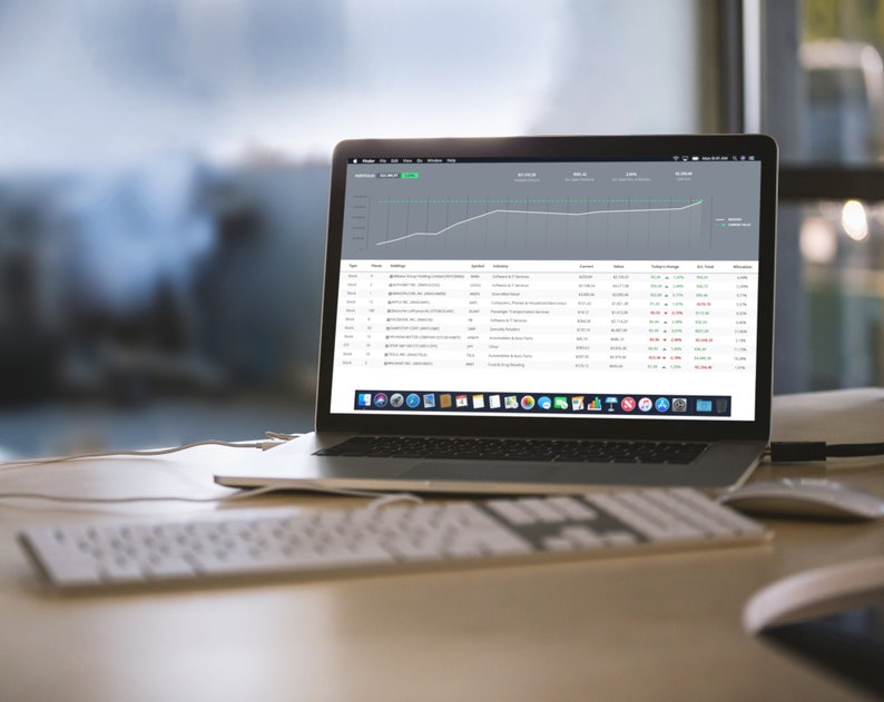 May include: A laptop computer with a white keyboard and a mouse on a wooden desk. The laptop screen displays a spreadsheet with a line graph showing an upward trend. The graph is labeled "Revenue" and the spreadsheet shows data for "Date", "Source", "Orders", "Revenue", "Change in Revenue", "% Change", and "Attribution".