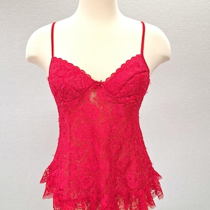 May include: A red lace lingerie top with a ruffled hem.