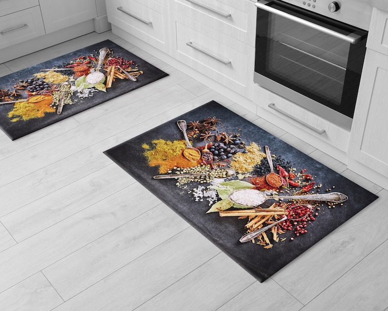 May include: Two kitchen rugs with a black background and a colorful design of various spices, herbs, and spoons.