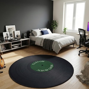 May include: A black vinyl record-shaped rug with the text "CUSTOM ALBUM COVER" in green. The rug is in a bedroom with a bed, desk, and guitar. The room has a modern aesthetic with neutral colors and minimalist decor.