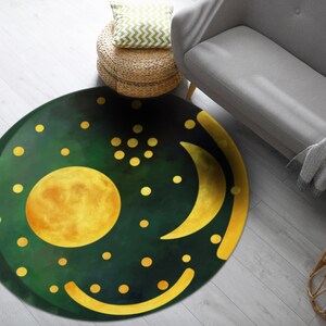Pode incluir: Um tapete redondo verde com uma lua crescente amarela, um c&iacute;rculo amarelo e pontos amarelos sobre um fundo verde escuro.