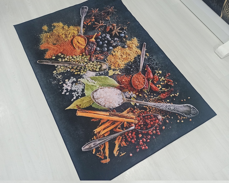 May include: A black background with various spices and herbs, including red pepper flakes, green peppercorns, and cinnamon sticks. There are also several silver spoons filled with different spices, including salt and red pepper.
