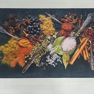May include: A black background with various spices and herbs in spoons and bowls. The spoons are silver and the bowls are white. The spices include cinnamon sticks, peppercorns, and dried herbs.