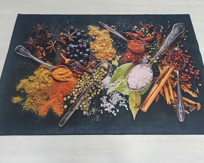 May include: A black background with various spices and herbs in spoons and bowls. The spoons are silver and the bowls are white. The spices include cinnamon sticks, peppercorns, and dried herbs.