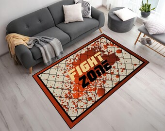 Könnte beinhalten: Rechteckiger Teppich mit cremefarbenem Hintergrund, einem roten und orangen Spritzmuster und einem schwarz-weißen Maschendrahtzaunmuster. Die Worte "FIGHT ZONE" stehen im Zentrum.