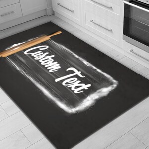 May include: A black and white kitchen rug with a rolling pin and the text "Custom Text" written in white on a white flour cloud.