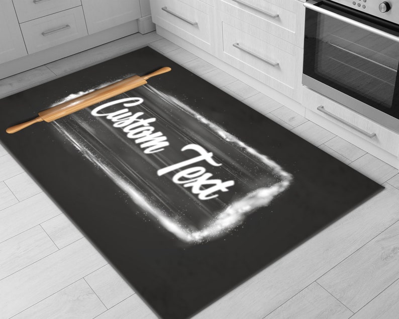 May include: A black and white kitchen rug with a rolling pin and the text "Custom Text" written in white on a white flour cloud.