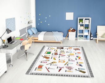 May include: A rectangular rug with a piano keyboard border and a white center featuring colorful illustrations of musical instruments and the alphabet. The rug is in a child's bedroom with a bed, desk, and shelving unit.