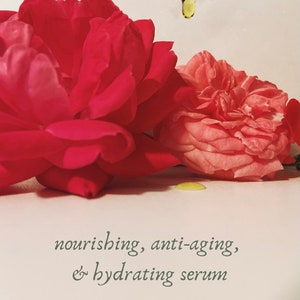 May include: A close-up of two roses, one deep red and the other light pink, with a dropper dispensing a yellow liquid. Text reads: nourishing, anti-aging, & hydrating serum, 100% organic & all natural.