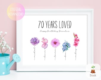 May include: A white framed print with the text "70 Years Loved" and "Happy Birthday Grandma". Five watercolor flowers are arranged vertically with names written below each flower: Michael, Kevin, Lauren, Dan, and Audrey.