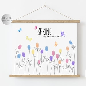 Könnte beinhalten: Druckbarer digitaler Download eines Frühlings-Kunstdrucks mit einer Blumenwiese, die mit bunten Fingerabdrücken und Schmetterlingen gestaltet ist. Der Text "SPRING is in the air" ist oben auf dem Druck in Schwarz geschrieben.
