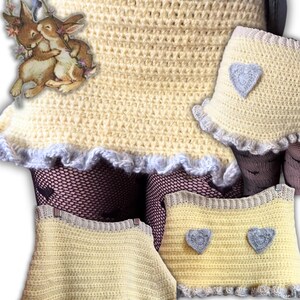 K&ouml;nnte beinhalten: Geh&auml;kelter gelber Rock und passende Accessoires mit grauem Besatz und Herzmotiven. Der Rock hat einen R&uuml;schensaum und wird mit Netzstr&uuml;mpfen kombiniert. Der Instagram-Handle @chloe.crochets_ ist unten zu sehen.