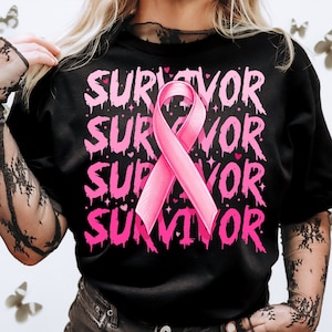 May include: Black t-shirt with the word "SURVIVOR" repeated four times in pink dripping letters. A pink ribbon is centered on the shirt.