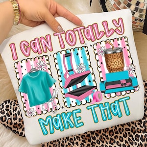 Puede incluir: Cojín blanco con el texto "I CAN TOTALLY MAKE THAT" en rosa y azul. El cojín presenta ilustraciones de una camiseta verde azulado, una prensa de calor y una bebida. El fondo tiene rayas rosas y azules.