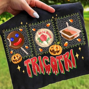 May include: Black Halloween-themed fabric with a gingerbread man lollipop, a "de la Rosa" candy, and a pumpkin. The word "TRICOTRI" is written in red and green. Candy corn and stars are scattered around the design.