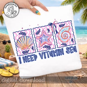 Pu&ograve; includere: Cuscino bianco con un design a tema spiaggia. Il design presenta tre illustrazioni incorniciate di una conchiglia, una stella marina e un nautilus, con il testo "I NEED VITAMIN SEA" in blu. Il cuscino &egrave; tenuto da una persona.