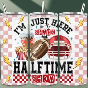 Può includere: Tre bicchieri in acciaio inossidabile con sfondo a scacchi rosa e bianco. I bicchieri presentano il testo "I'm Just Here for the Snack and Halftime Show" con illustrazioni di football e snack.
