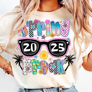 May include: A white t-shirt with a colorful graphic design that says "Spring Break 2025" with sunglasses and palm trees.