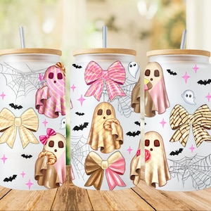 Puede incluir: Tres vasos blancos con tapas y pajitas presentan un diseño de temática de Halloween con fantasmas, lazos y murciélagos. Los fantasmas llevan atuendos rosas, marrones y beige con lazos. Los lazos son rosas, marrones y beige con lunares blancos. Los murciélagos son negros.