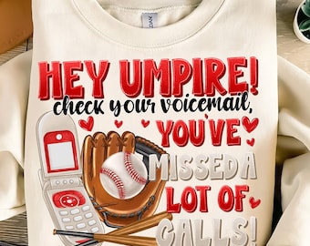 May include: A white sweatshirt with a red graphic print that says "Hey Umpire! Check your voicemail, You've Missed a Lot of Calls!" The graphic includes a baseball, a glove, a baseball bat, and a cell phone.
