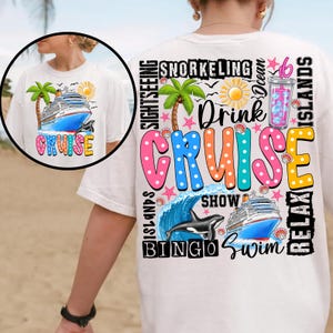 May include: White t-shirt with a colorful graphic design that says "Drink Cruise" with images of a cruise ship, palm trees, a dolphin, and a wave. The text around the graphic says "Relax Islands", "Bingo Swim", "Show", "Snorkeling", "Drink", "Sightseeing", and "Relax Islands".