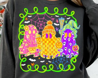 Puede incluir: Sudadera gris oscuro con un diseño de Halloween. El diseño muestra tres fantasmas de dibujos animados en varios colores y patrones, rodeados de telarañas, murciélagos y un borde verde neón. Un fantasma sostiene una calabaza.