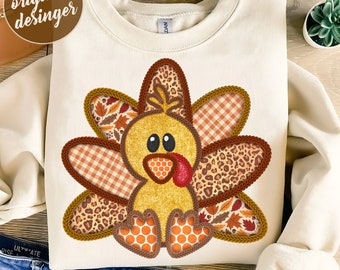 Puede incluir: Un diseño digital que presenta un lindo pavo de dibujos animados con un diseño de patchwork. El pavo está hecho de diferentes telas, incluyendo cuadros, estampado de leopardo y hojas de otoño. El diseño es perfecto para proyectos de sublimación, como camisetas, tazas y bolsas de mano.