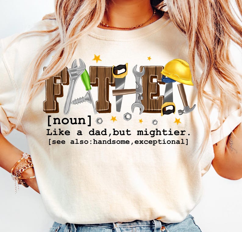 May include: Cream-colored t-shirt with the word "FATHER" in a brown, block letter design, incorporating tools like a wrench, saw, and hammer. The text below reads "Like a dad, but mightier."
