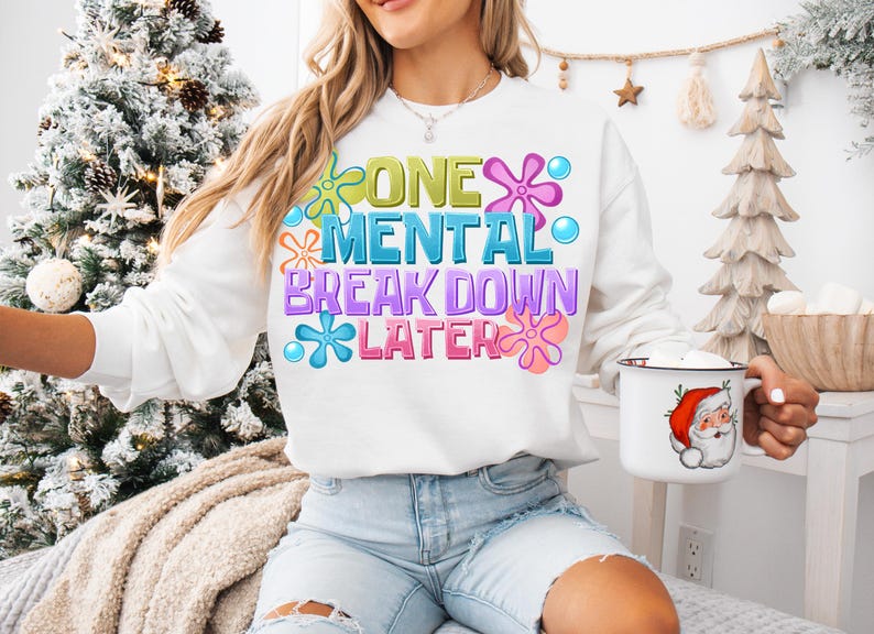May include: White sweatshirt with a colorful graphic that says "One Mental Breakdown Later" with a flower design.
