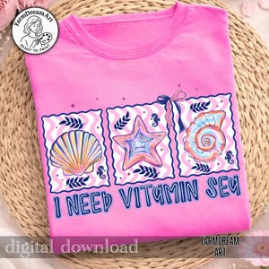 Pu&ograve; includere: T-shirt rosa con un design grafico raffigurante una conchiglia, una stella marina e una conchiglia a spirale. Il design include il testo "I NEED VITAMIN SEA". La maglietta ha uno scollo tondo ed &egrave; realizzata in materiale morbido.