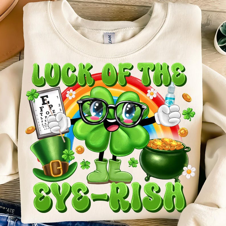 May include: A white sweatshirt with a green four-leaf clover wearing glasses and holding an eye chart. The text "LUCK OF THE EYE-RISH" is printed on the shirt.