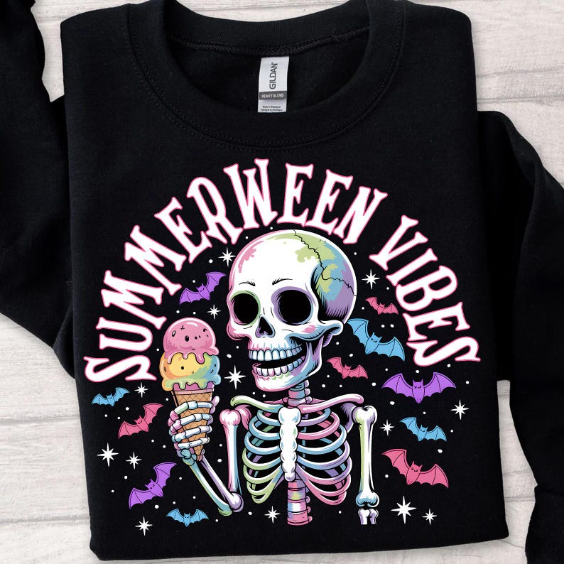 May include: Black sweatshirt with a colorful skeleton graphic holding an ice cream cone. The design includes the text "SUMMERWEEN VIBES" in a curved font, with bats and stars. The skeleton's skull has a rainbow gradient.