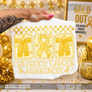 May include: A white fabric item featuring a gold-colored graphic with a checkered border, two bows, and a central awareness ribbon. The text reads Childhood Cancer Awareness. The design includes small heart shapes and a repeating ribbon pattern.