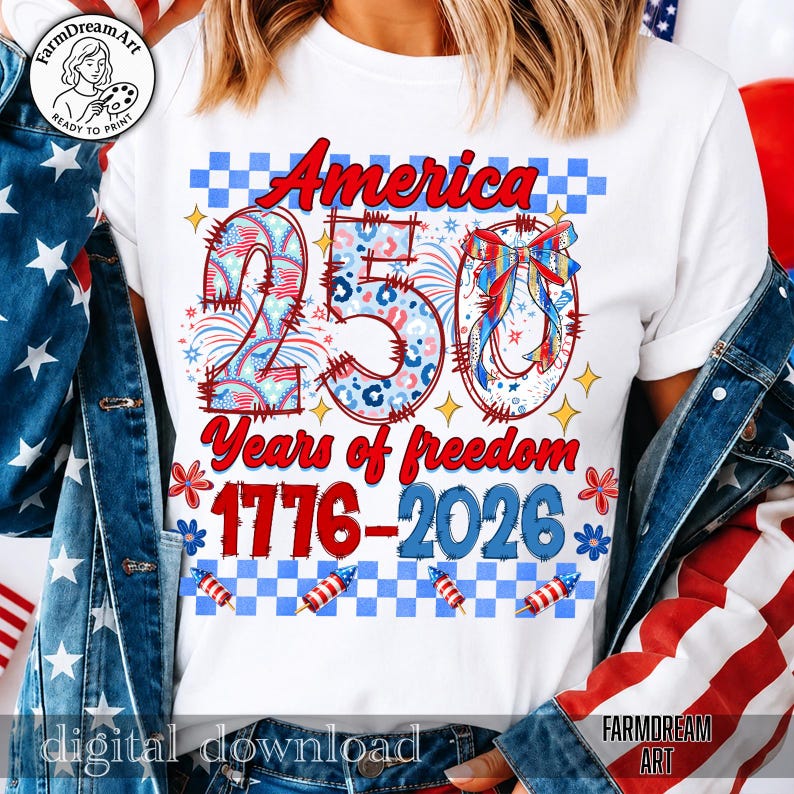 May include: White t-shirt with a patriotic design celebrating 250 years of American freedom. The design features the word "America" in red, the number "250" with stars and stripes, and the years "1776-2026". Includes fireworks and floral accents.